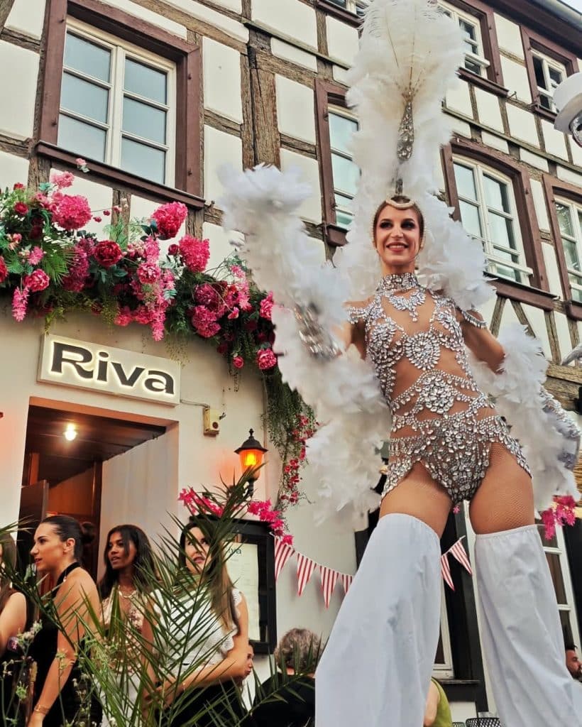 Soirée animée devant le Riva Strasbourg, danseuse sur échasses